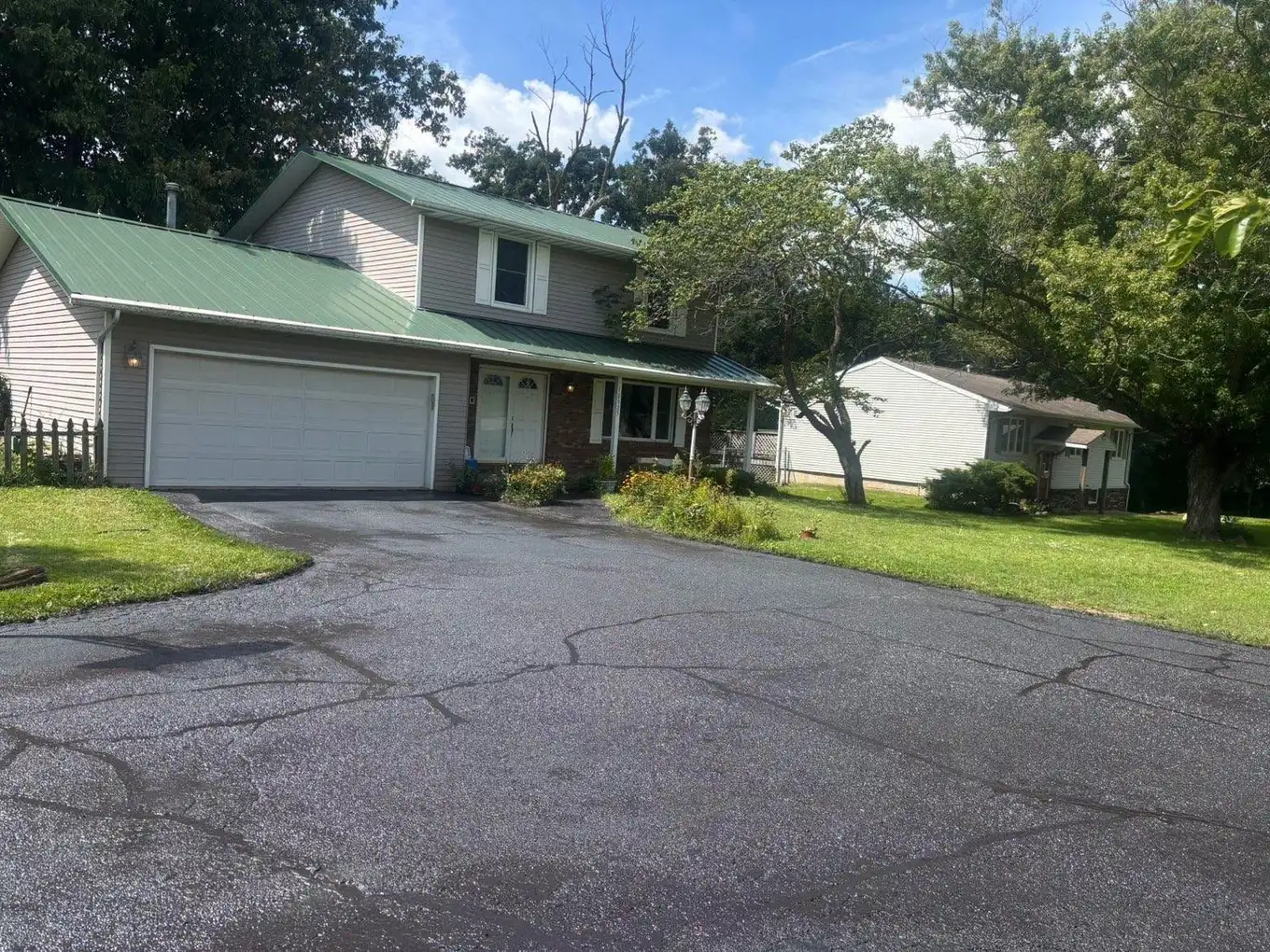 The same residential driveway after crack filling and a coat of sealer, dark and even.