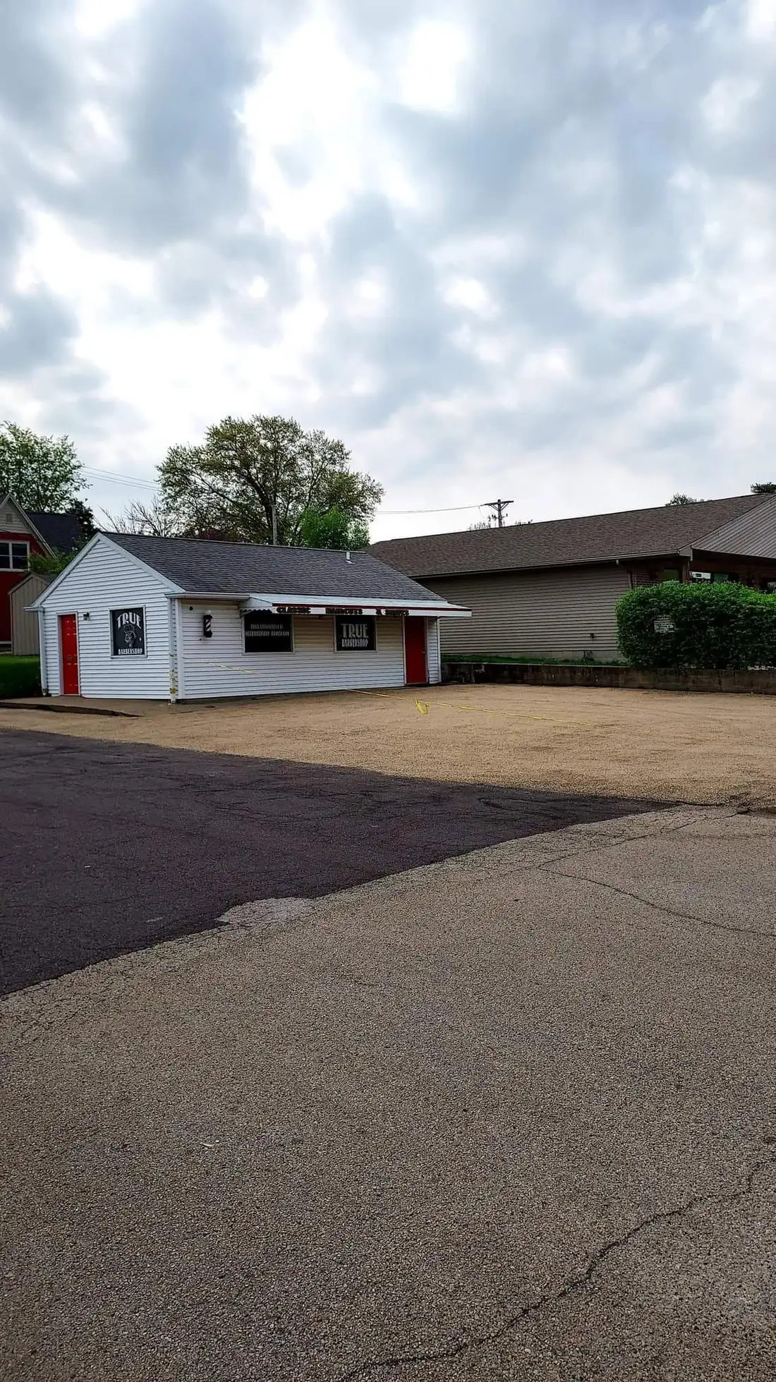 A commercial lot beside a small business building, graded flat and compacted ready for surfacing.